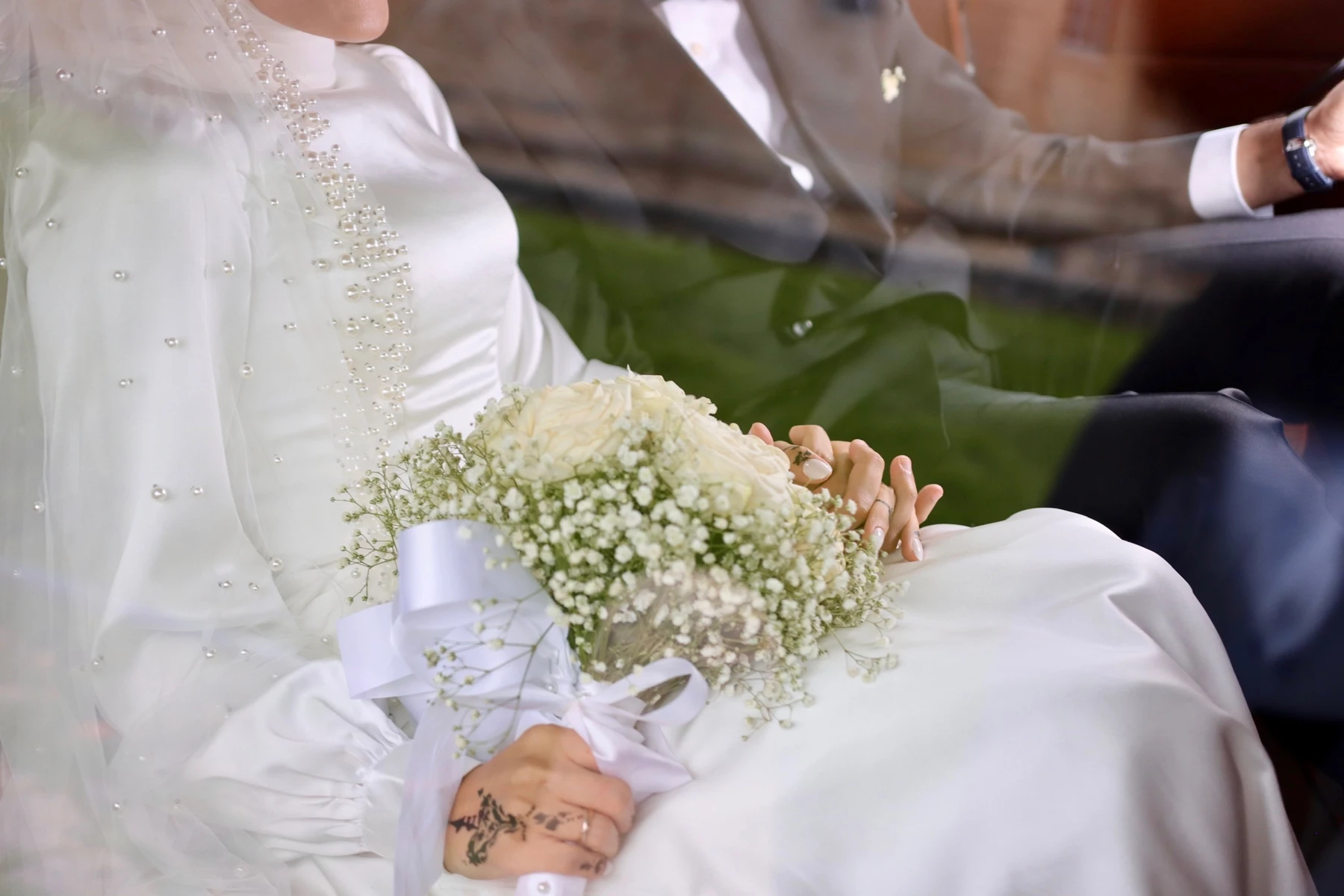 Bouquet blanc sur les genoux de la mariée dans la voiture